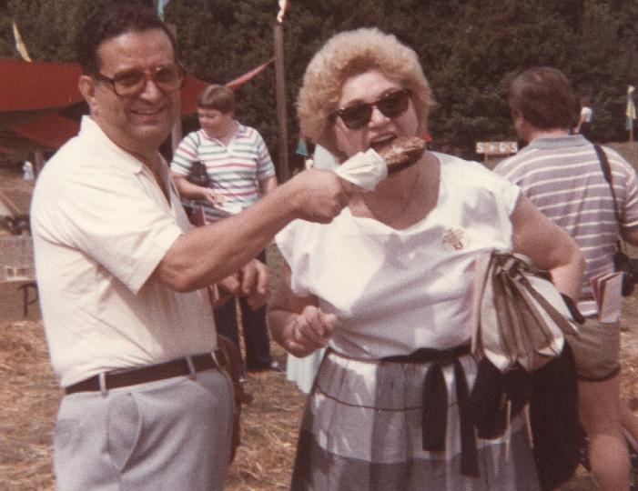 p056.jpg - Dad feeding Mom a turkey leg at the Rennaisance Festival, Sept. 1984.