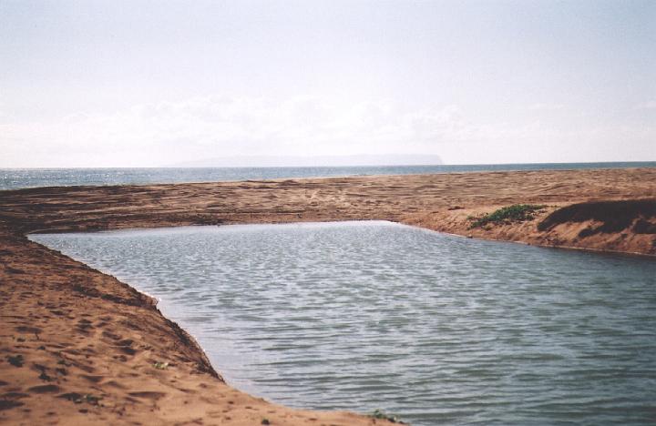 h039.jpg - A canal in Kekaha, Kauai, almost reaching the ocean. That is the island of Ni'ihau in the distance.